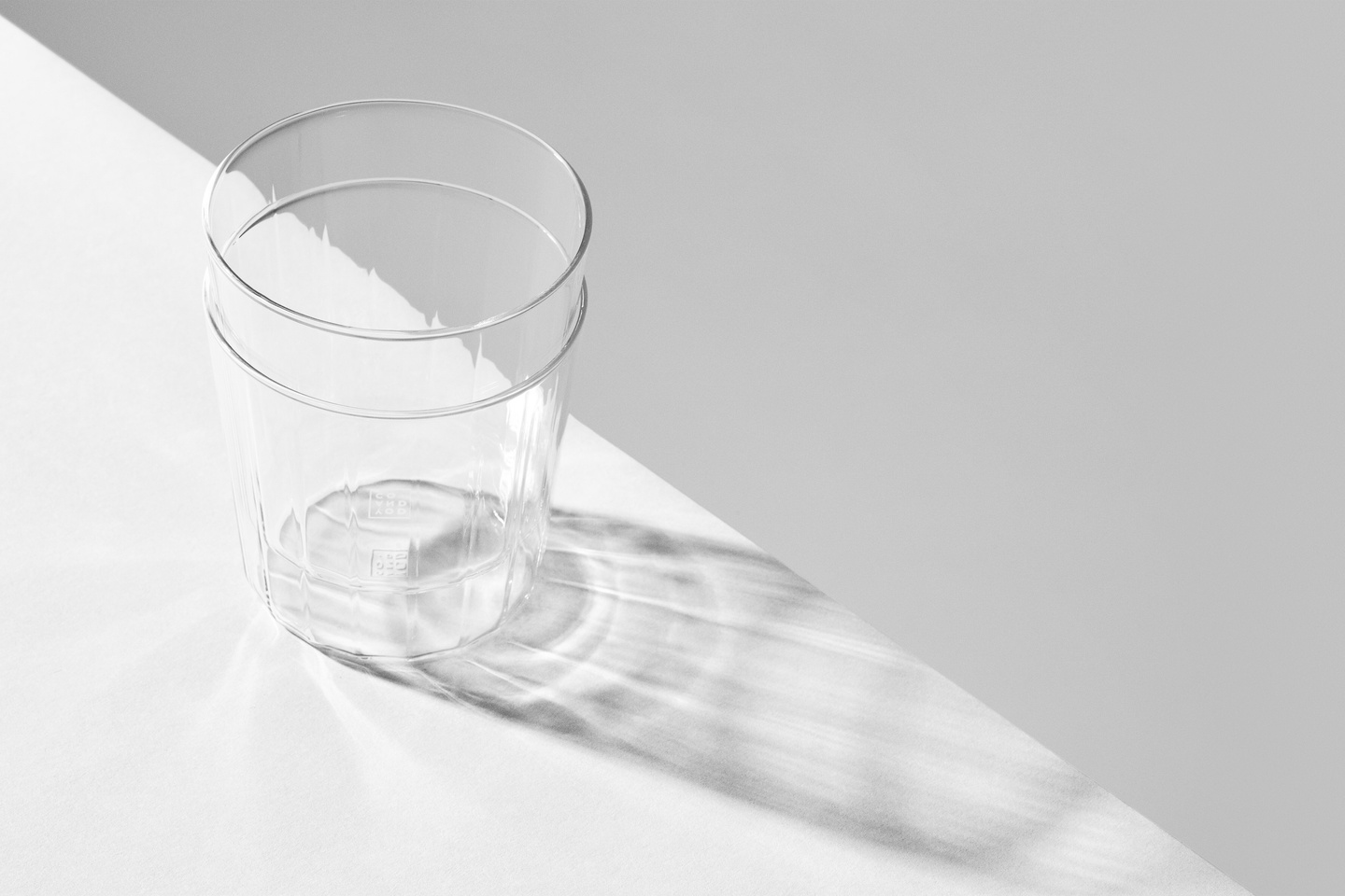 Light shadow reflection cast by clear glass on a white background