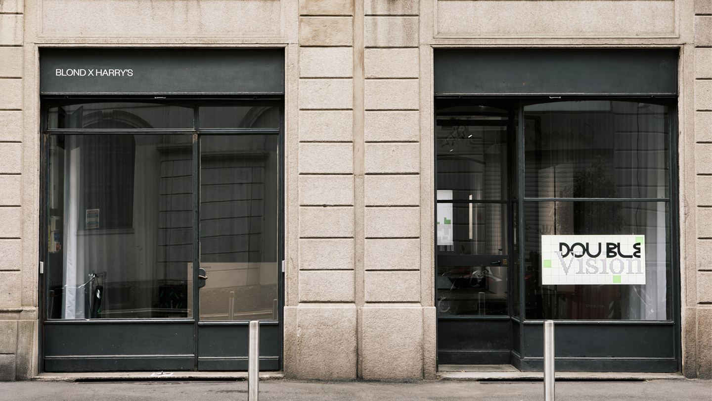 Exterior view of a building facade with glass doors and white window graphics