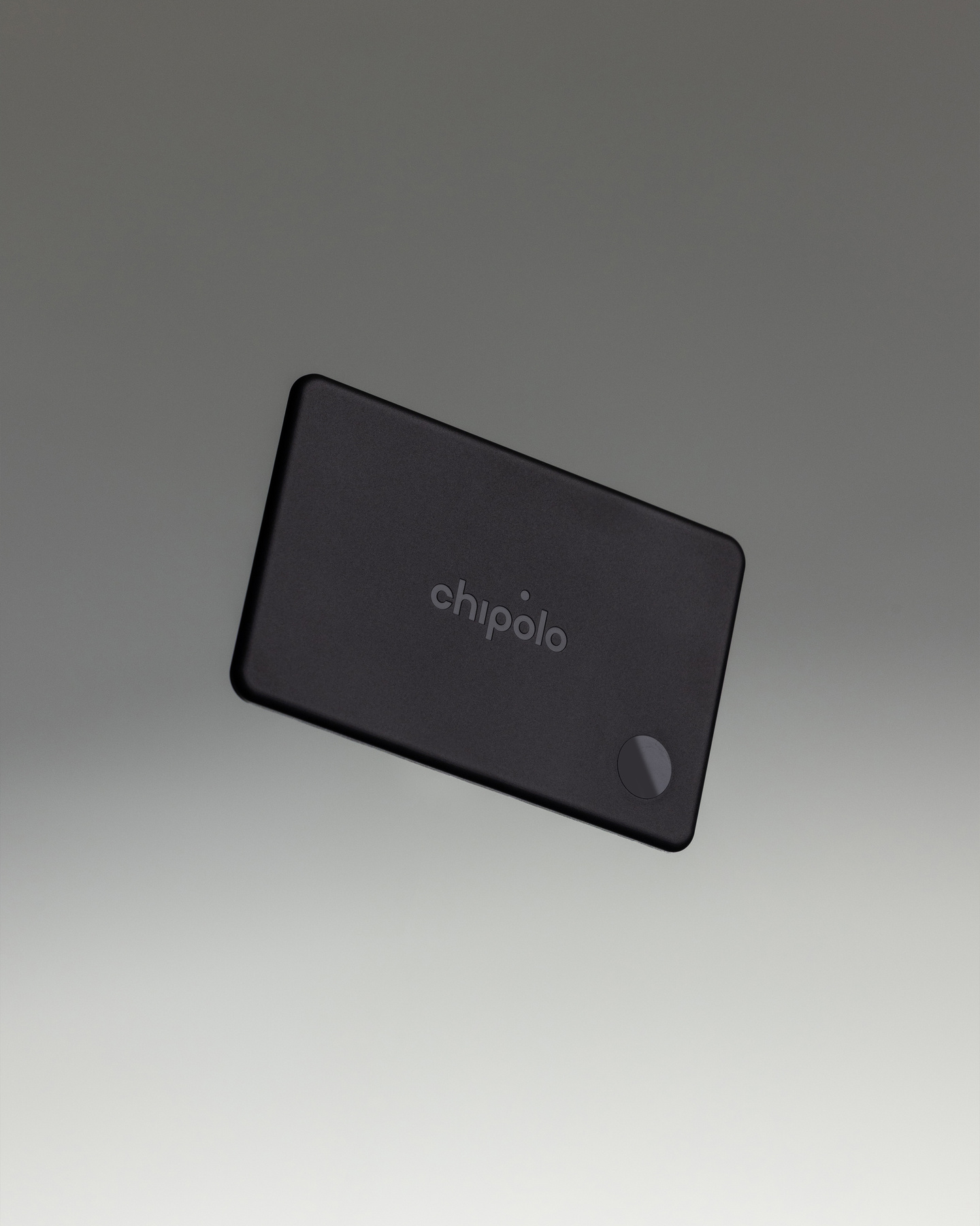 Rectangular dark Chipolo Card tracker angled on a light grey studio background.