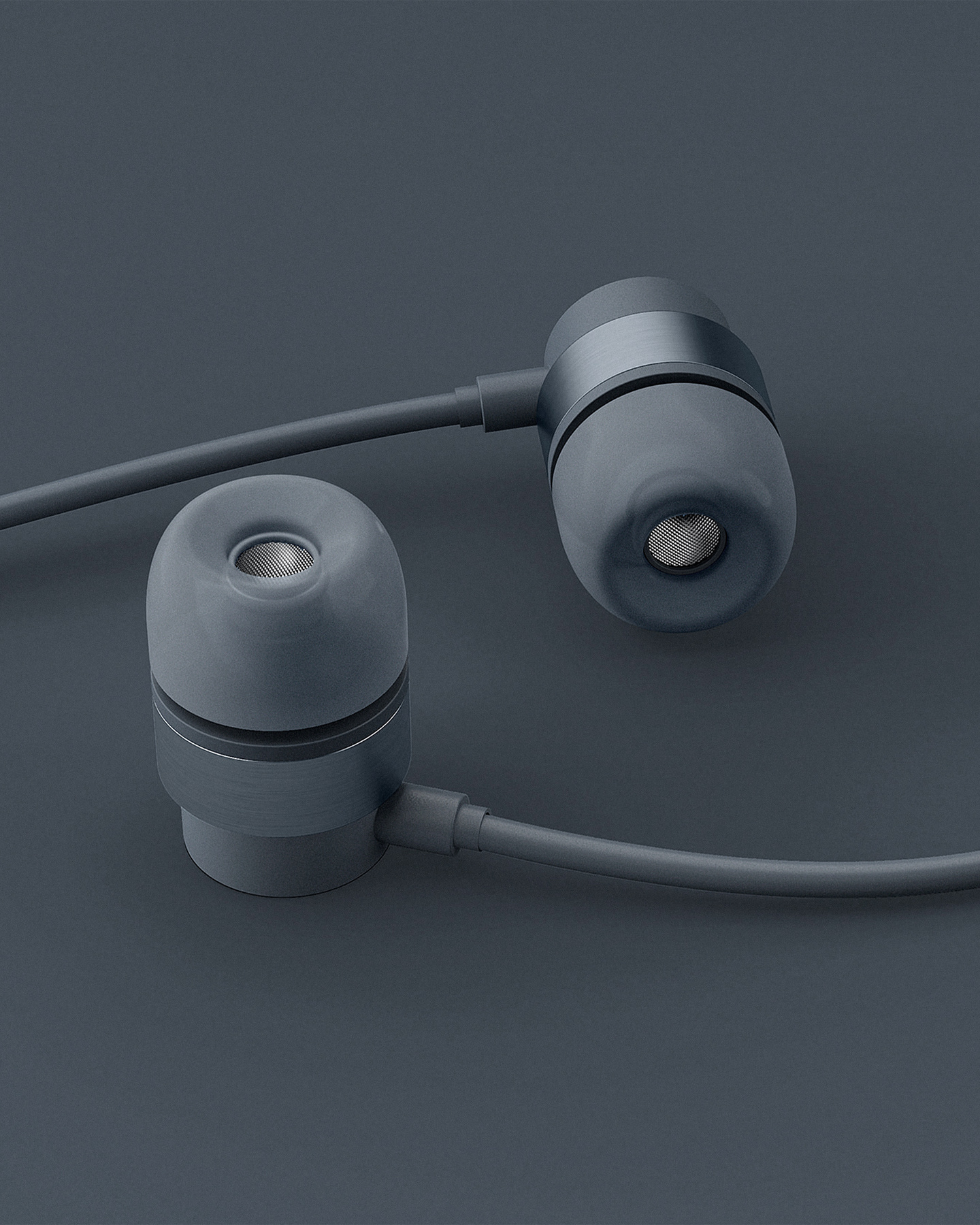 Pair of grey in-ear wired headphones resting on a dark grey background