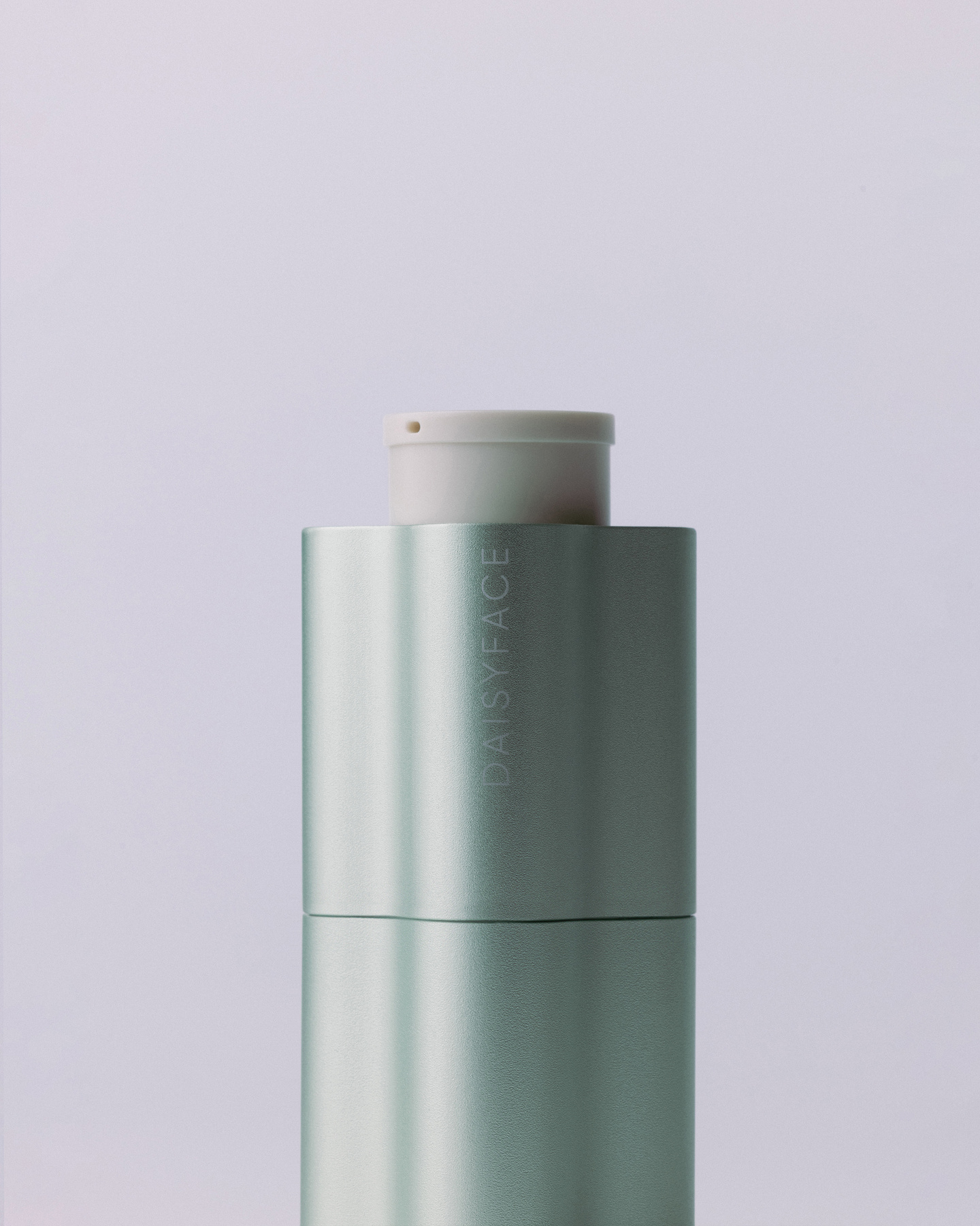 Small silver metallic bottle standing on light background