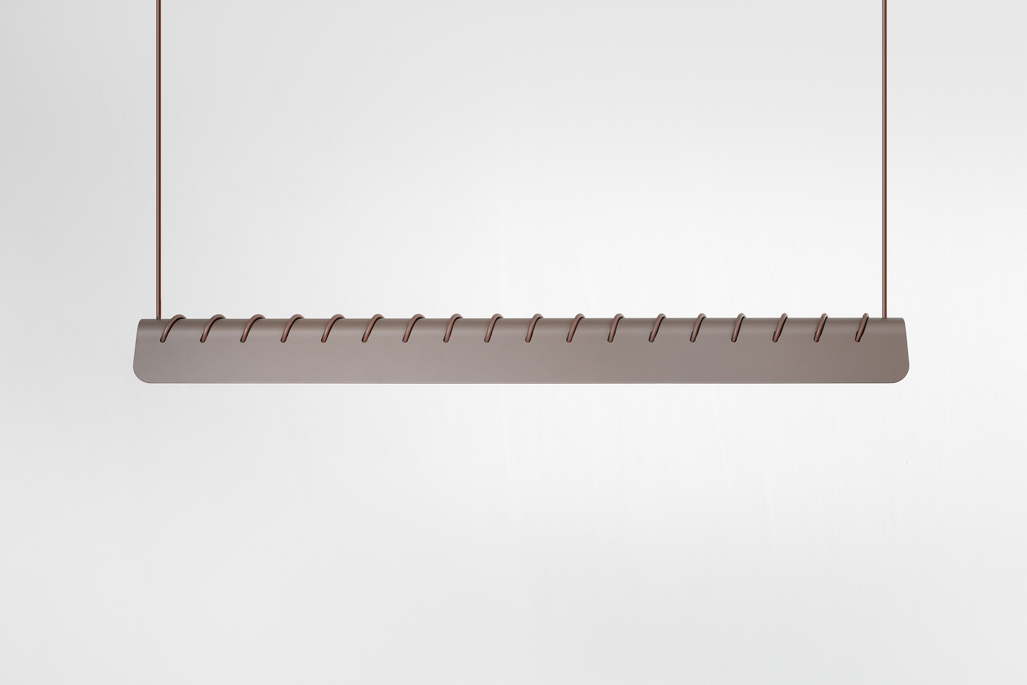 Studio shot showing the full profile of a suspended horizontal linear pendant lamp.