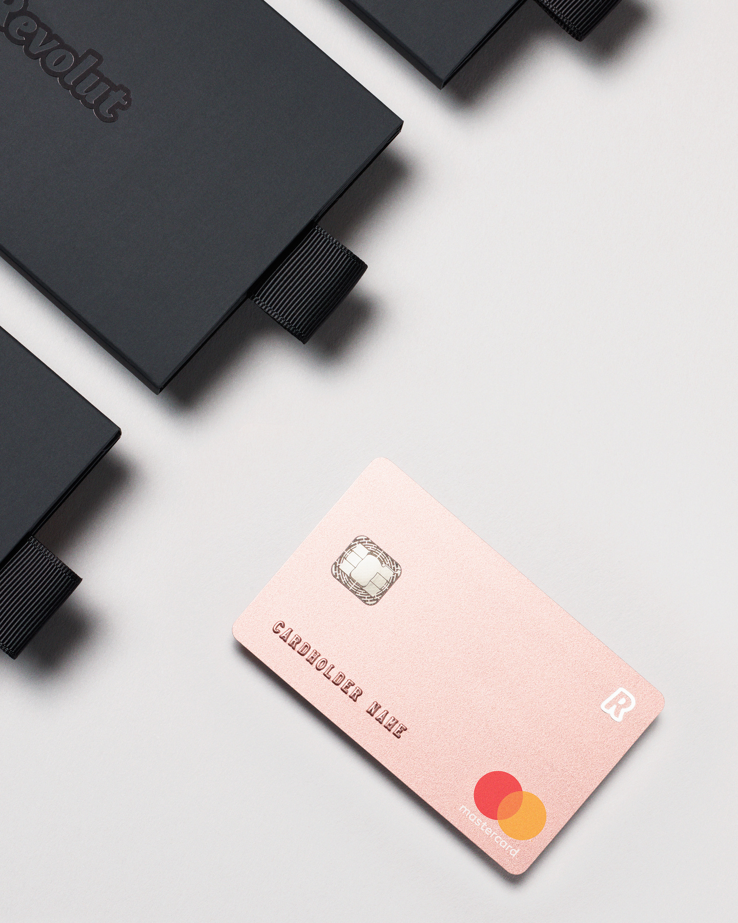 Rose gold Revolut card positioned inside an open black sleeve.