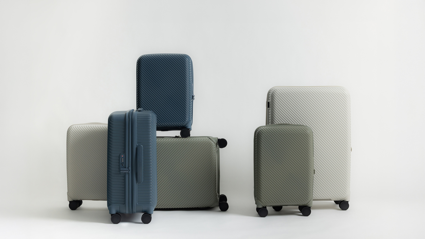 Blue and grey hardshell suitcases arranged on a light background