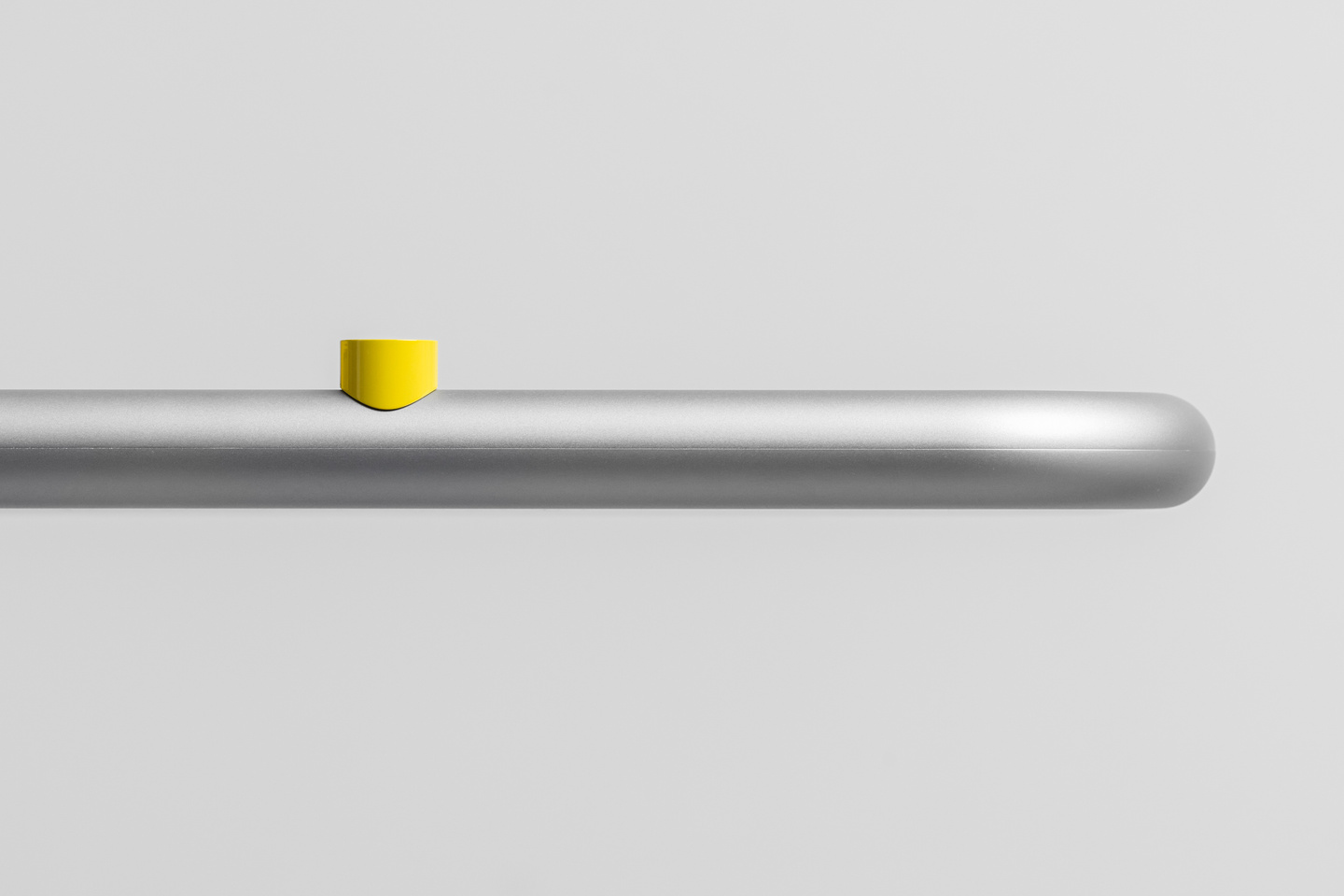 Close-up view of a thin metal rail with a yellow dial element