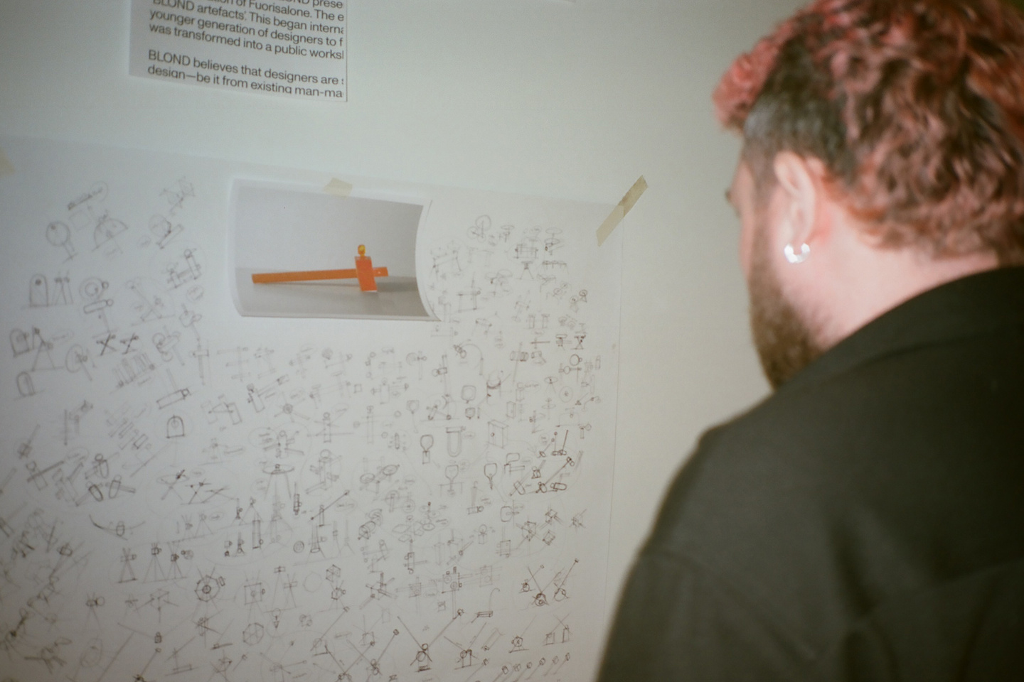 A person looking at the sketches for the BLOND laboratory exhibition