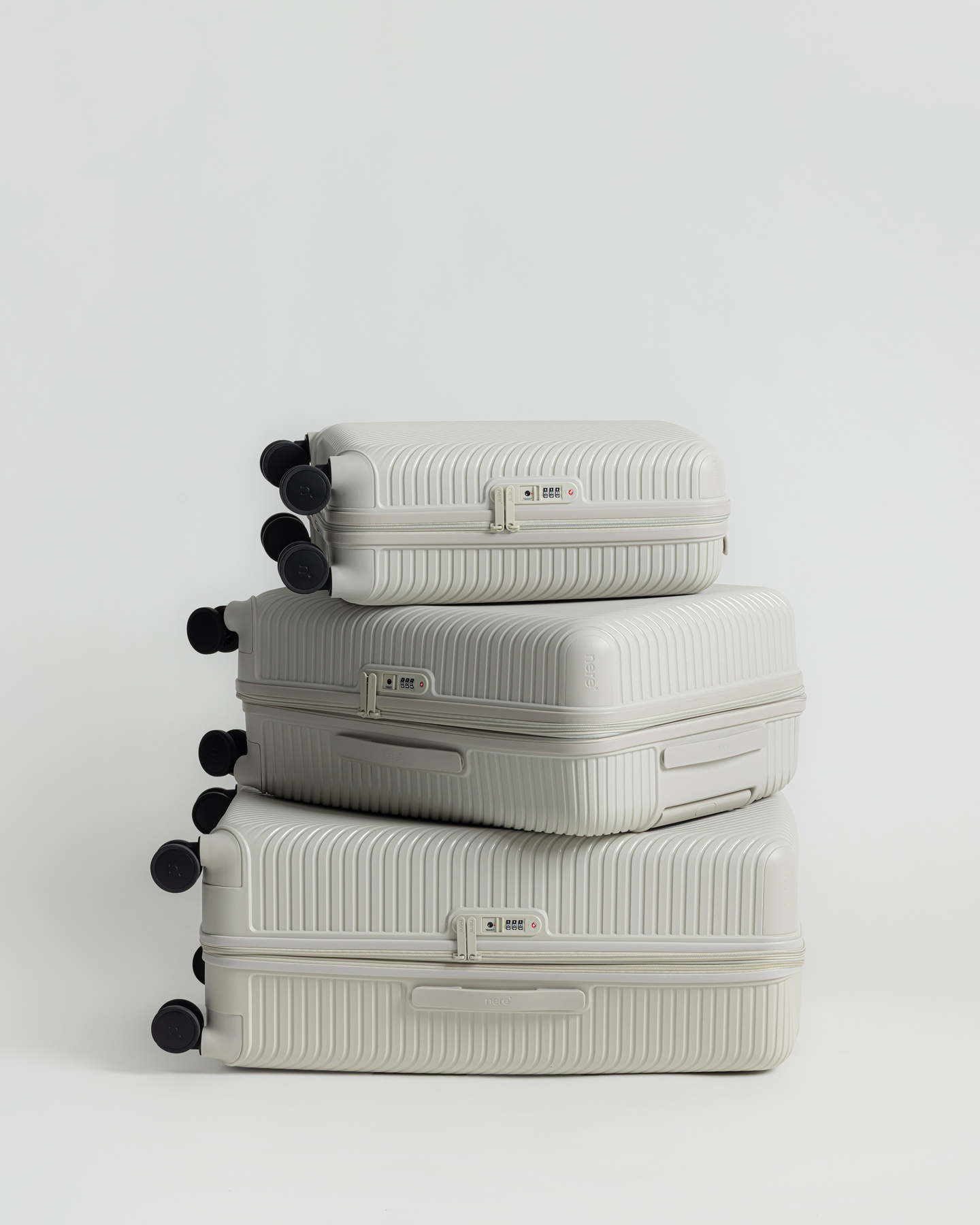 Three white hardshell suitcases stacked on top of each other