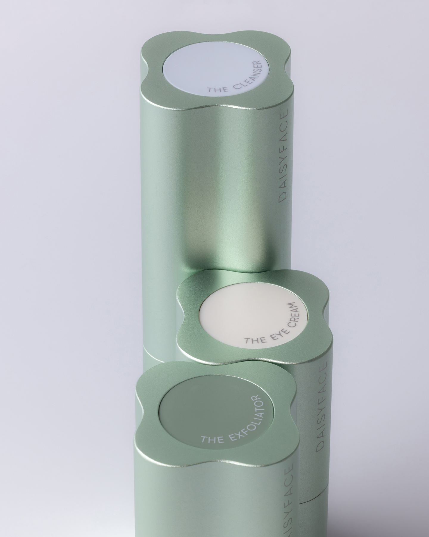 Three light green fluted skincare bottles standing together