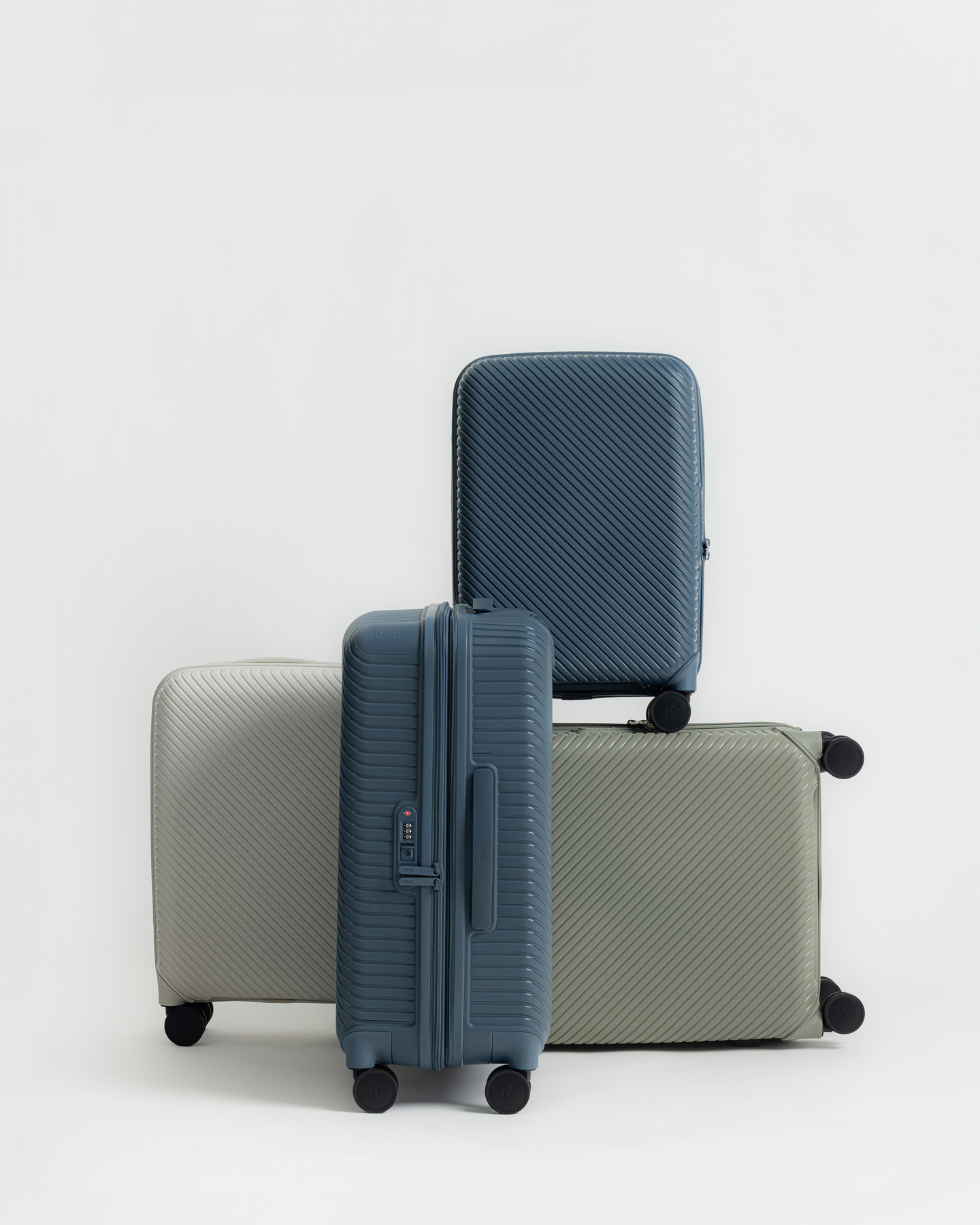 Blue and grey hardshell suitcases stacked on a light surface