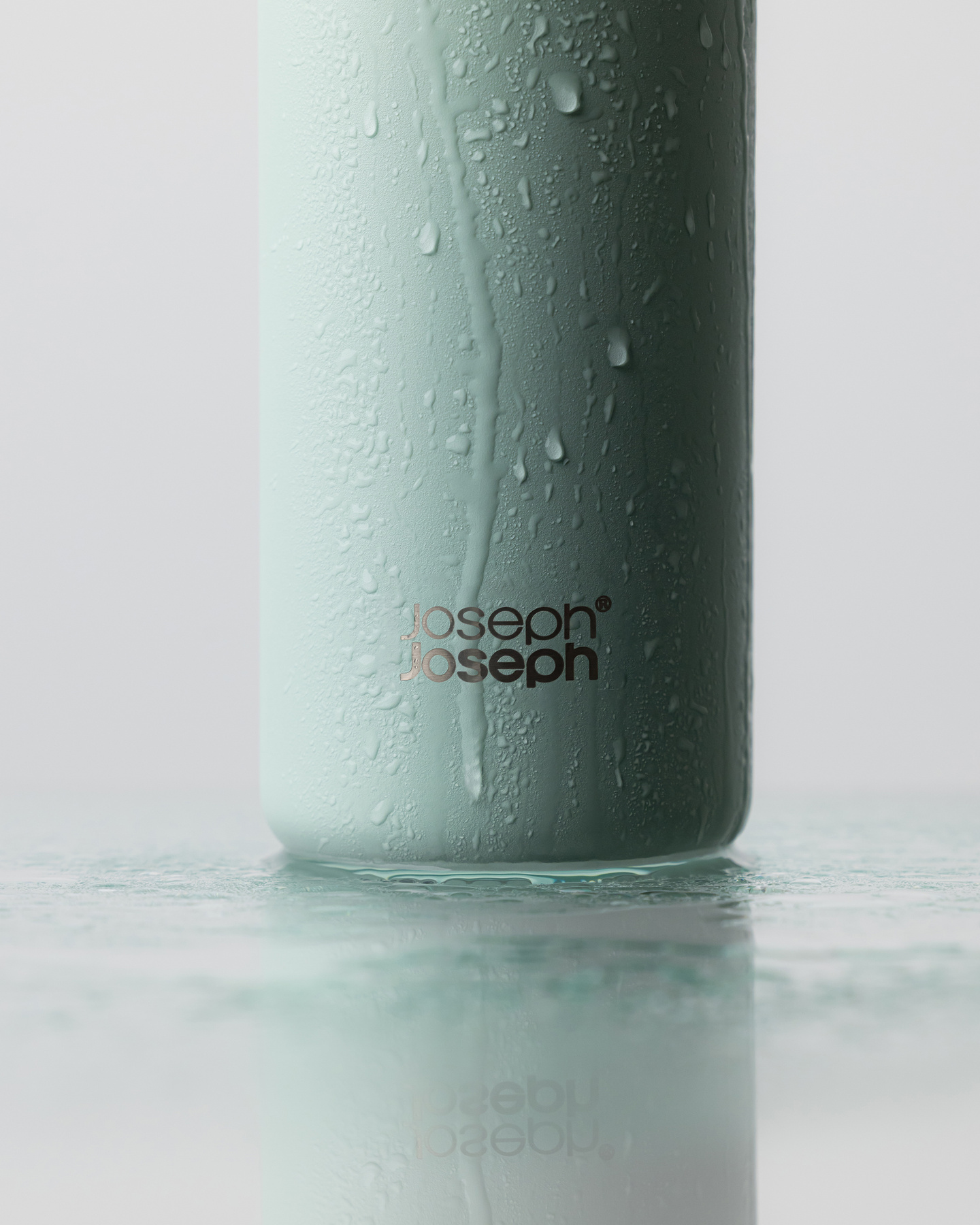 Close-up of water droplets on the base of a green water bottle