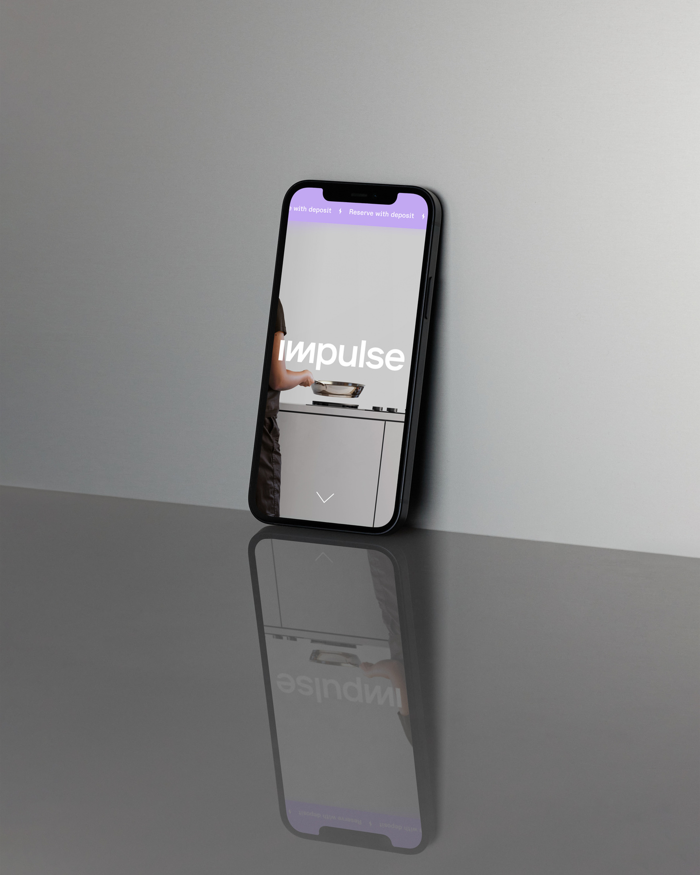Mobile phone standing upright on a reflective grey surface