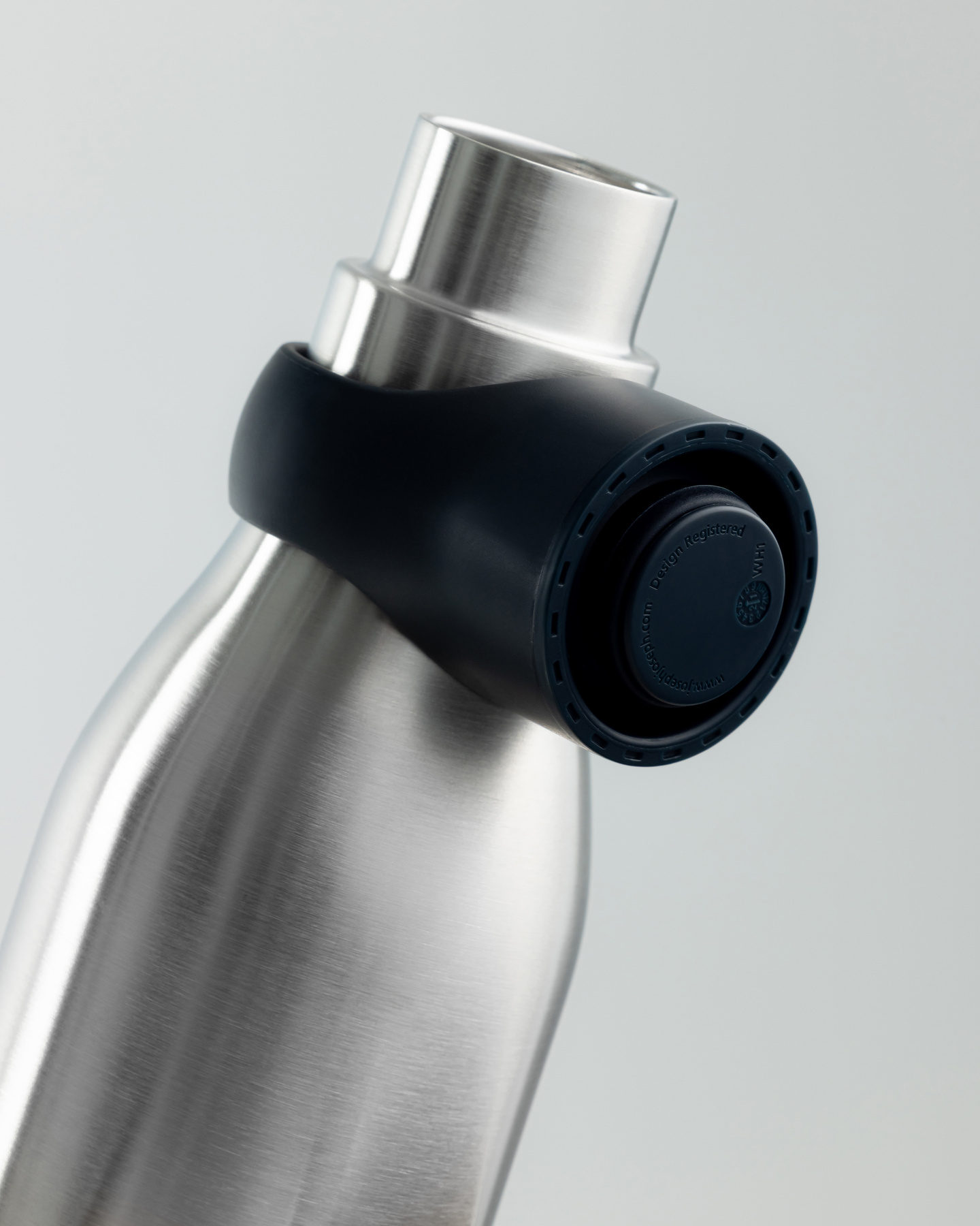 Close-up of stainless steel water bottle with black collar cap attachment