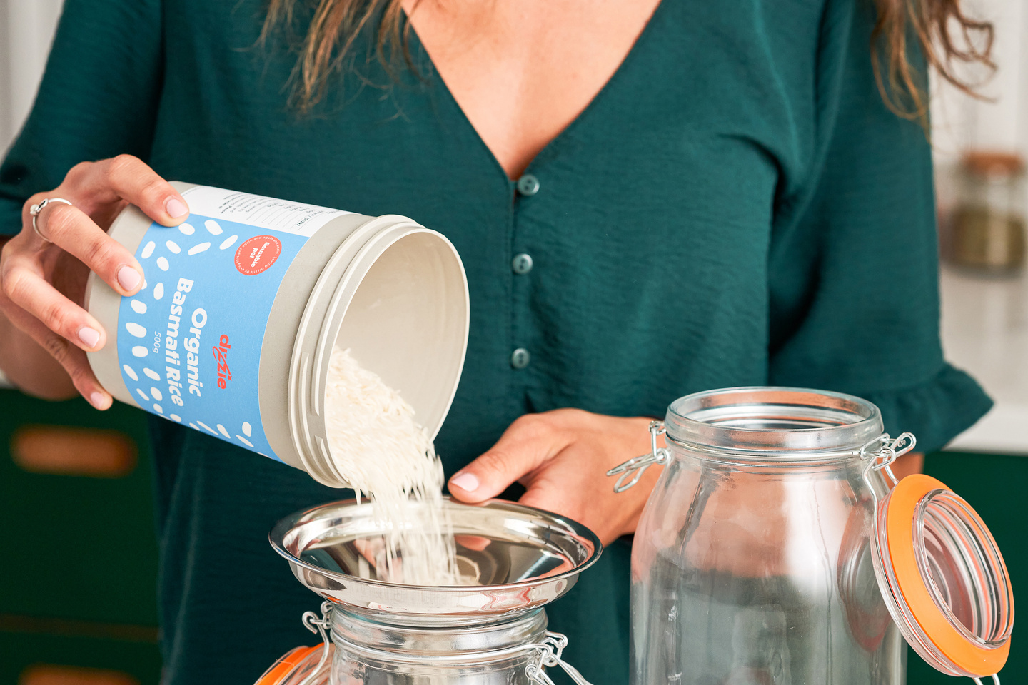 Hands holding a small reusable grocery container with a blue lid.