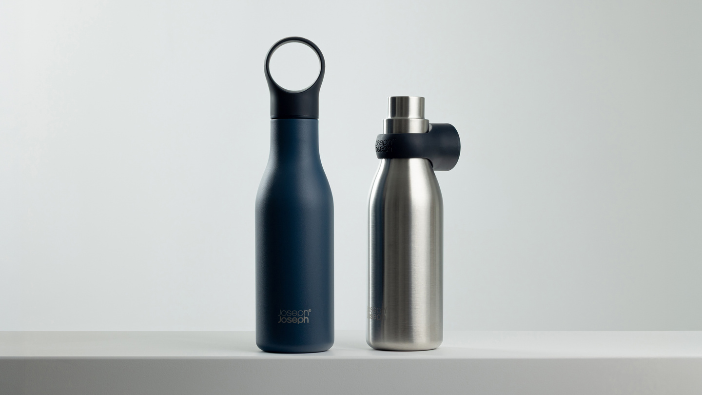 Dark blue and stainless steel water bottles standing together on a ledge