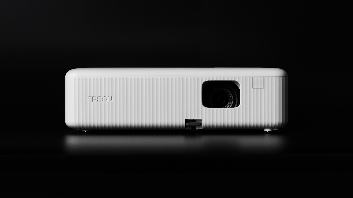 White ribbed compact home projector standing on a black surface