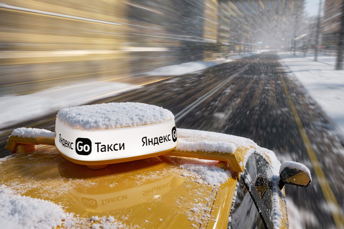 Close-up view of a Yandex Go rooftop sign on a snow-dusted car roof