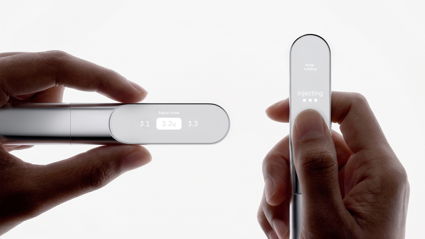 Hands holding a white smart insulin pen showing its integrated digital display