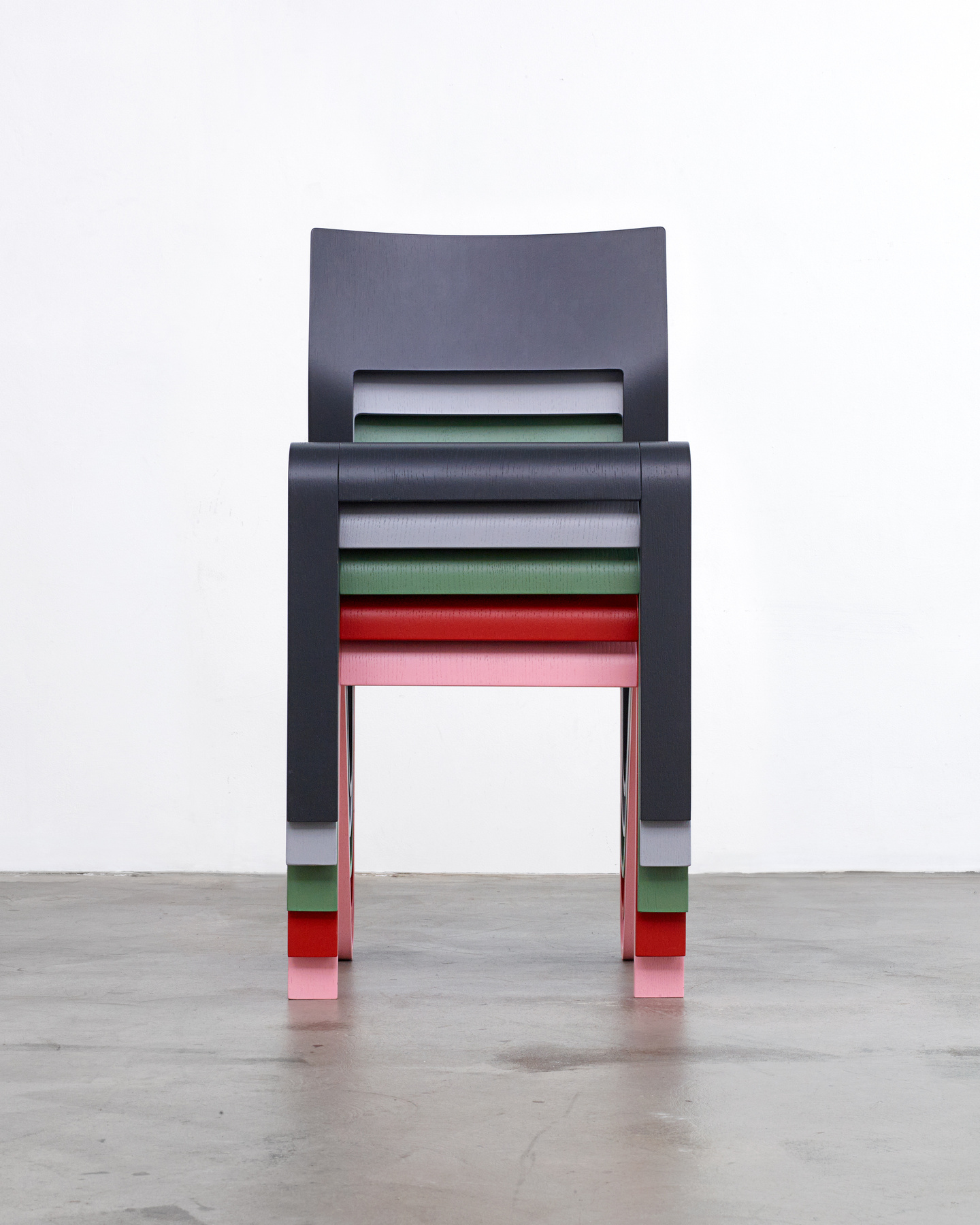 Front view of four colorful wooden chairs stacked neatly on top of each other.