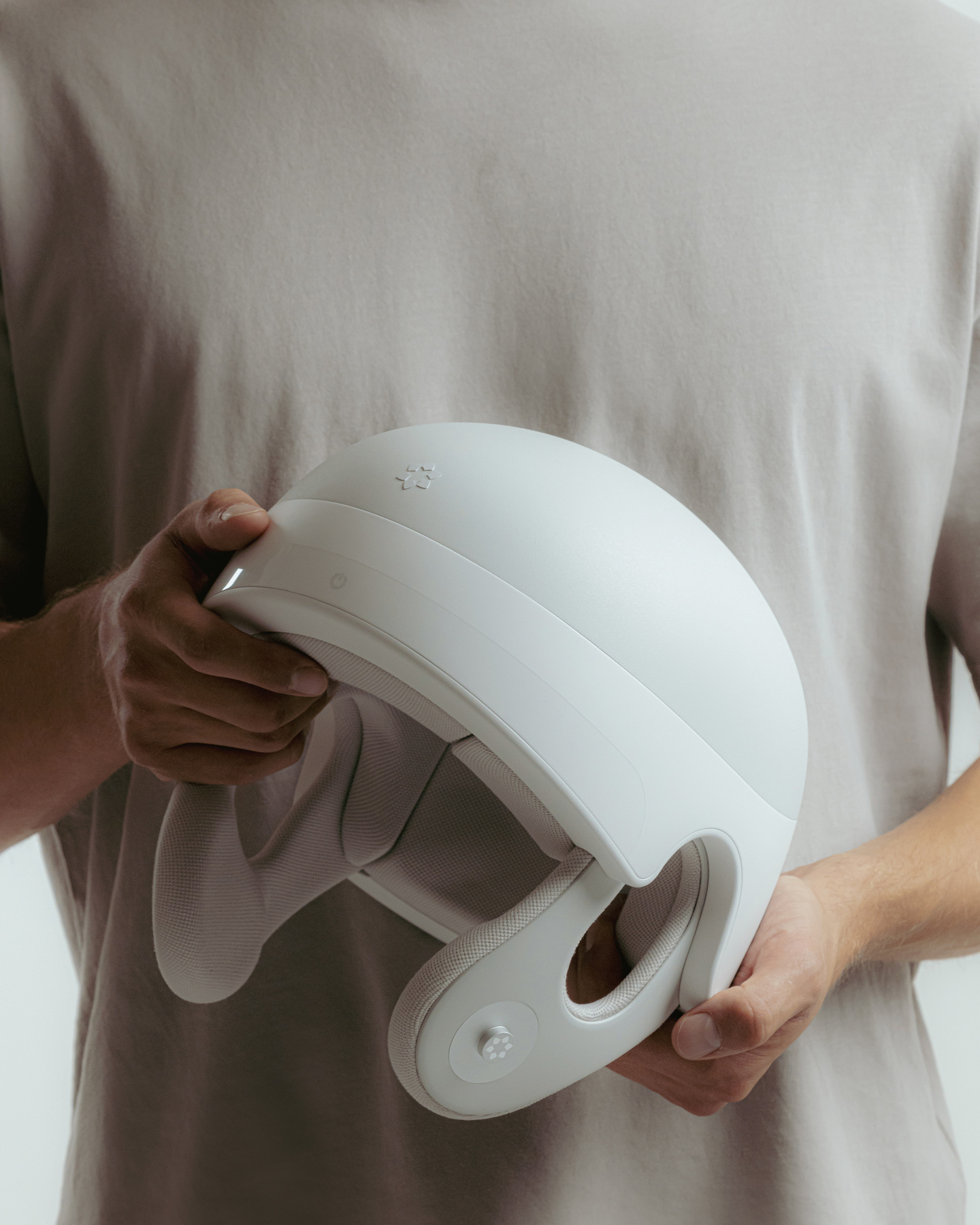 Person holding a white medical wearable helmet with both hands