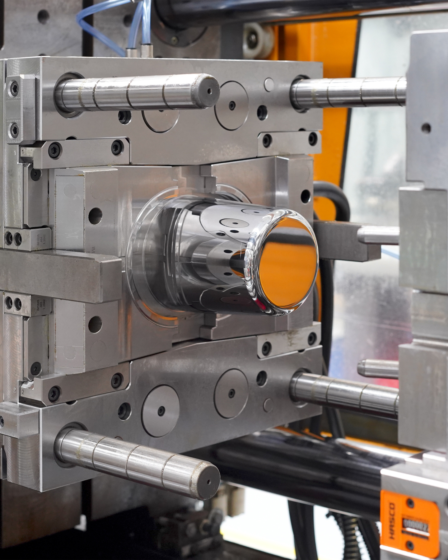 Close-up of injection moulding tool in factory setting.
