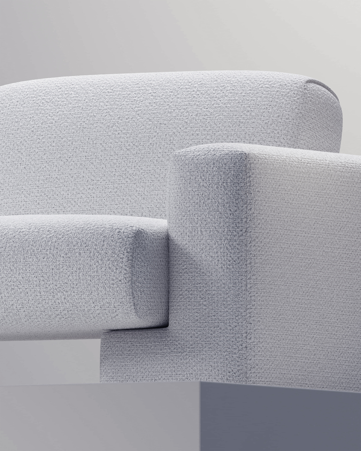 Close-up view of the upholstered armrest and cushion of a grey fabric sofa