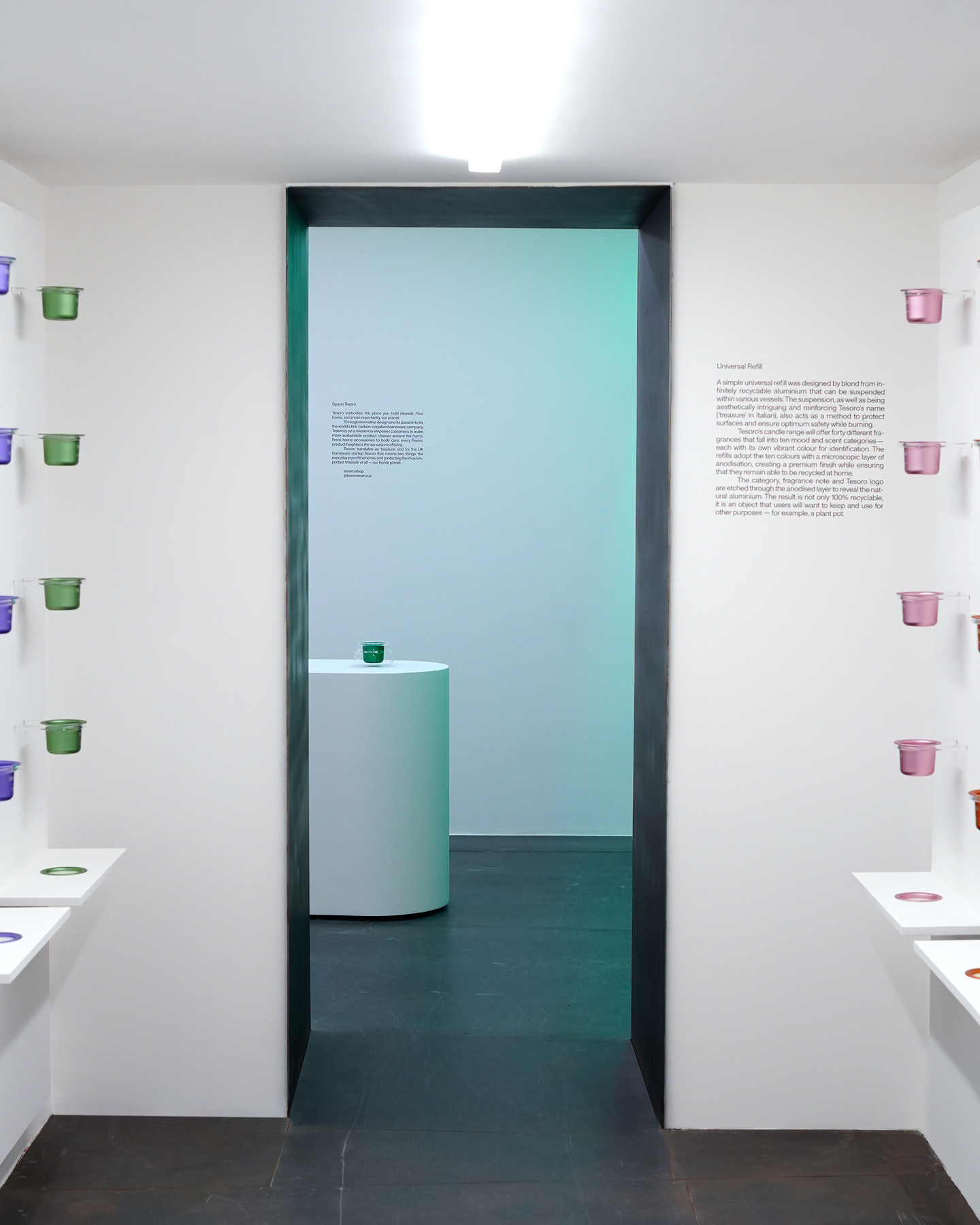View looking through a doorway into an exhibition room illuminated with teal ambient light.