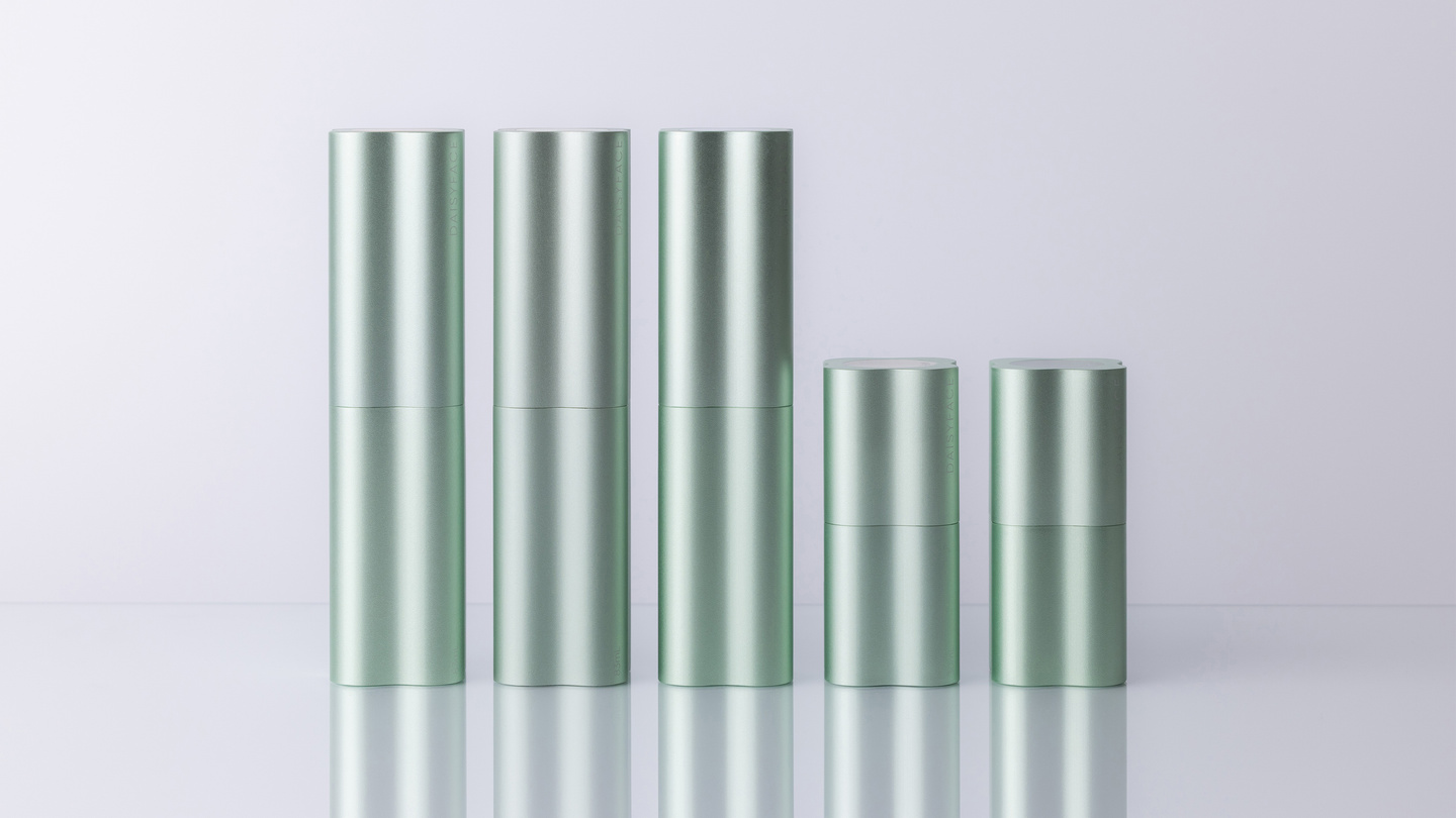 Row of light green fluted skincare containers on a light surface