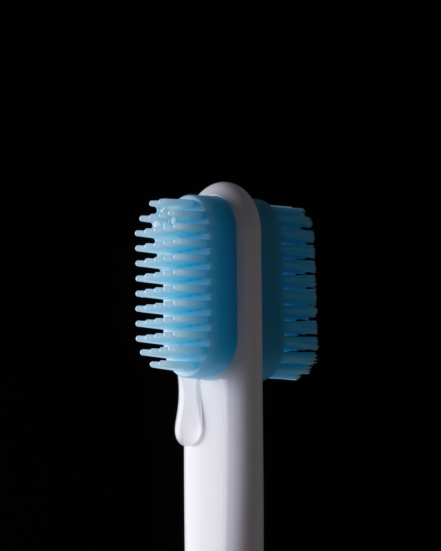 Bright blue bristle brush attachment head on a dark background