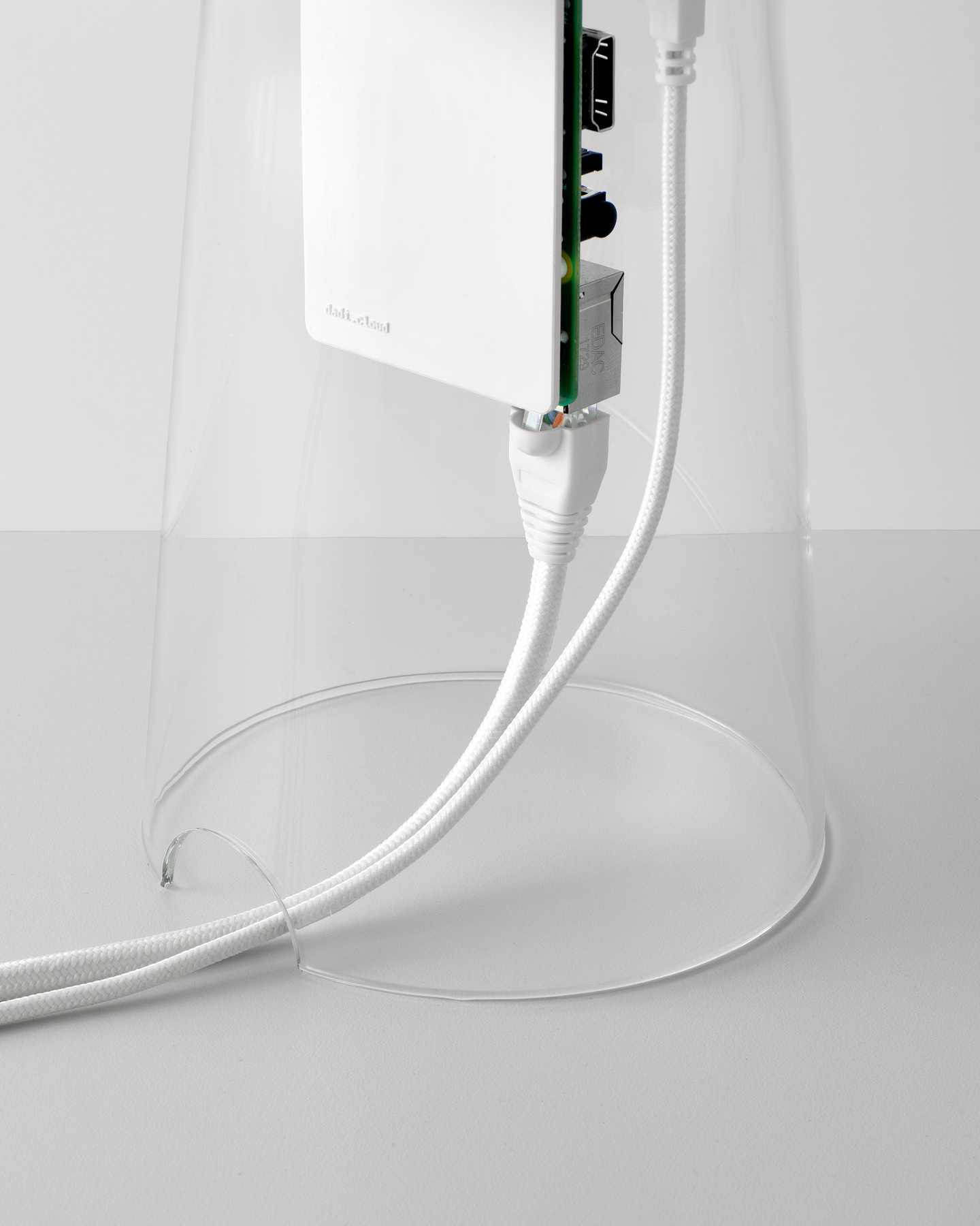 White power cable connected to internal circuit board inside clear glass cylinder.