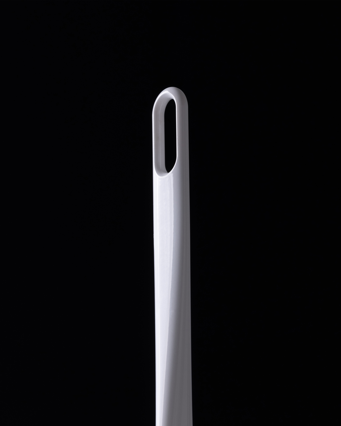 Transparent applicator tip of a hair styling tool on a dark background