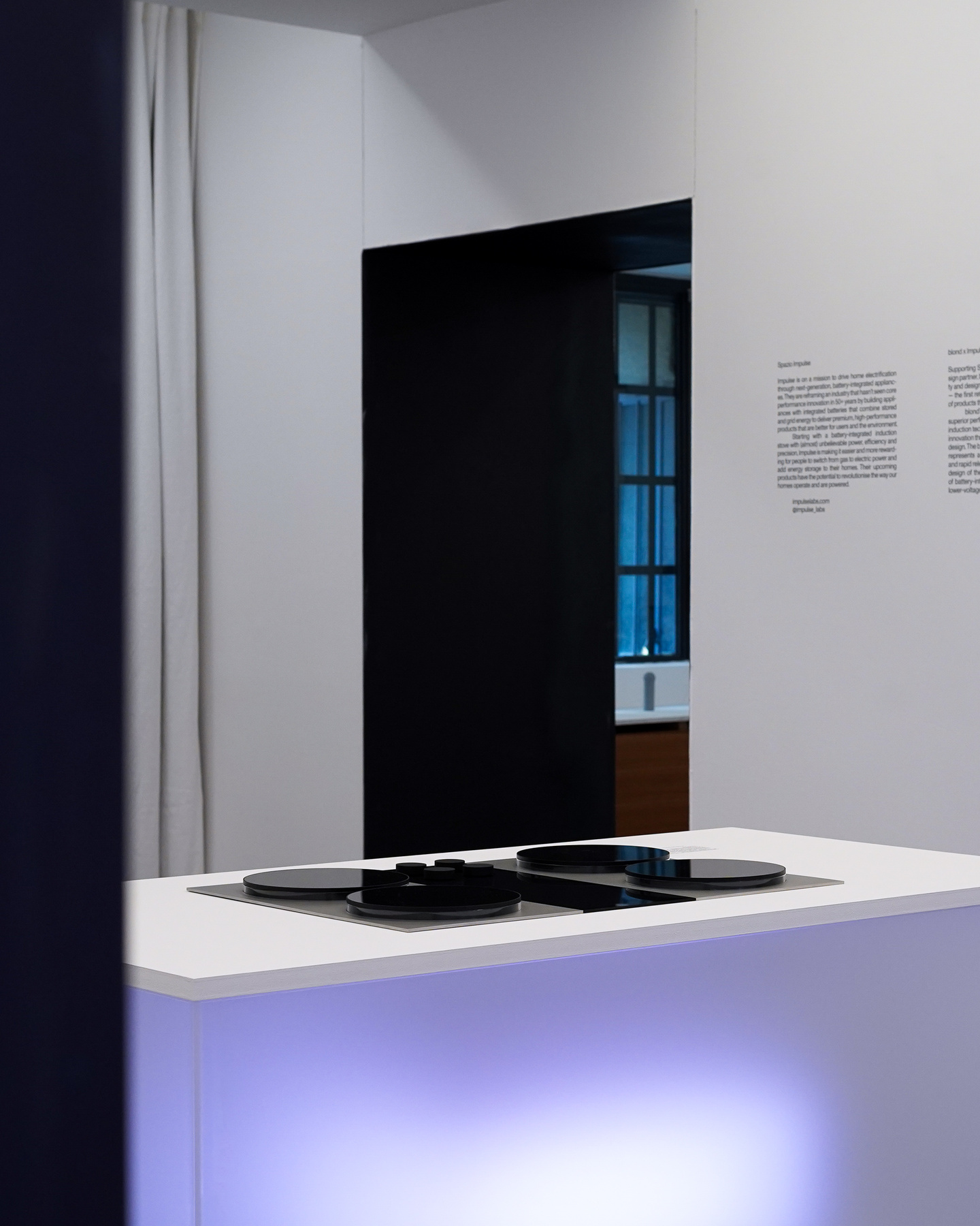 Black electronic device presented on a purple backlit display plinth.
