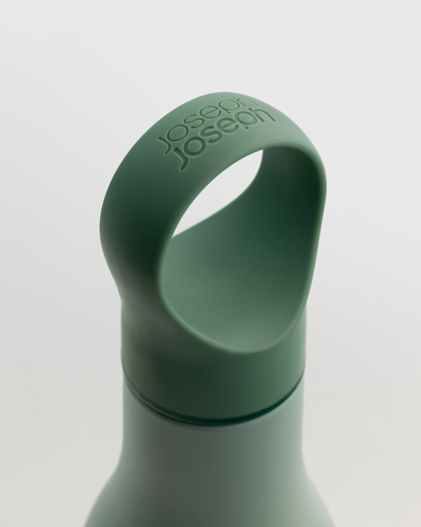 Close-up view of the green silicone loop handle on a water bottle neck