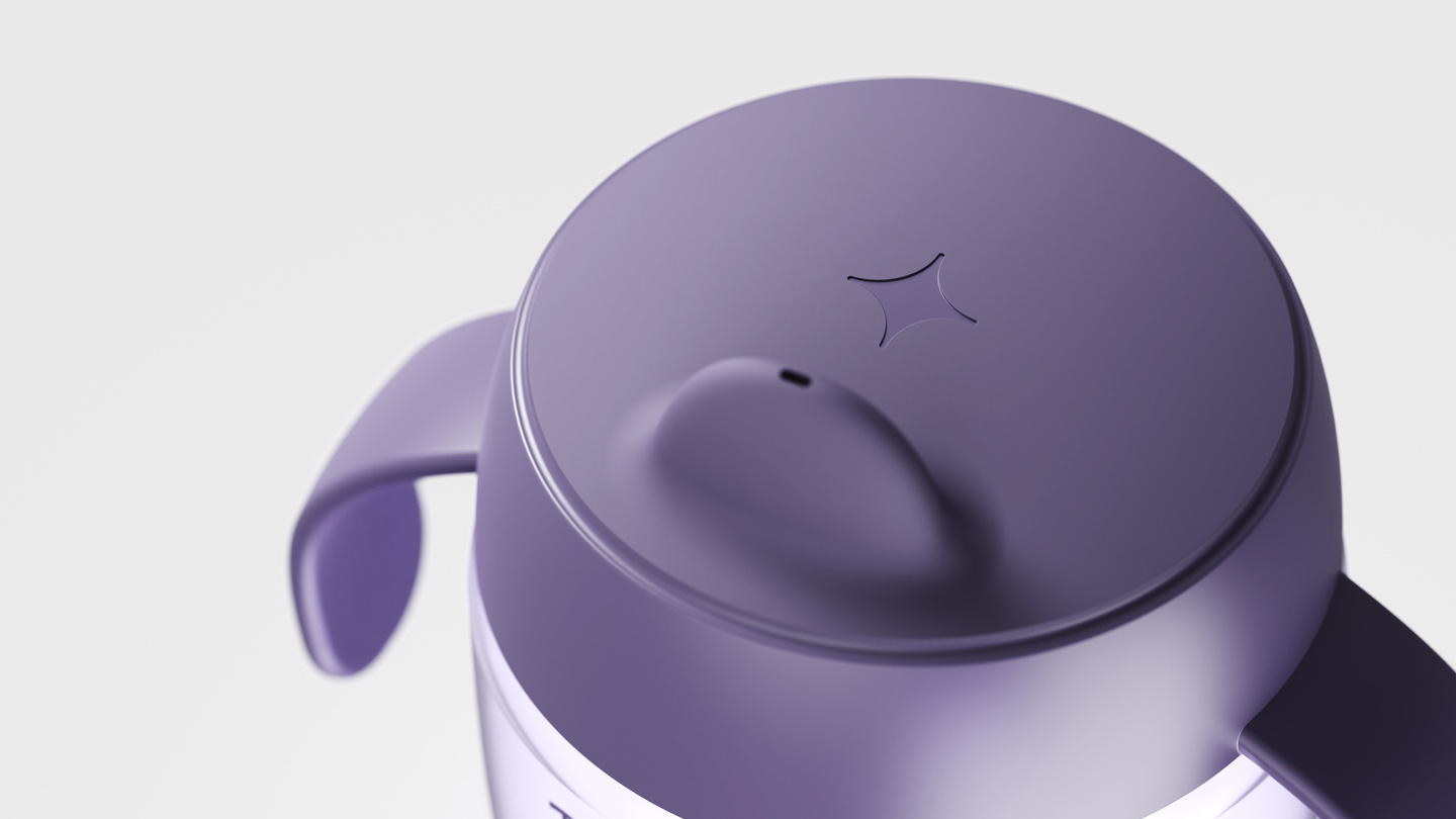 Angle view of a purple sippy cup lid with handles on white background