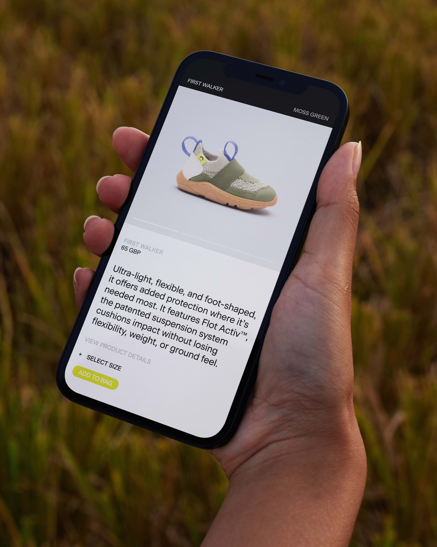 Hand holding a mobile phone displaying the Brightland e-commerce website.