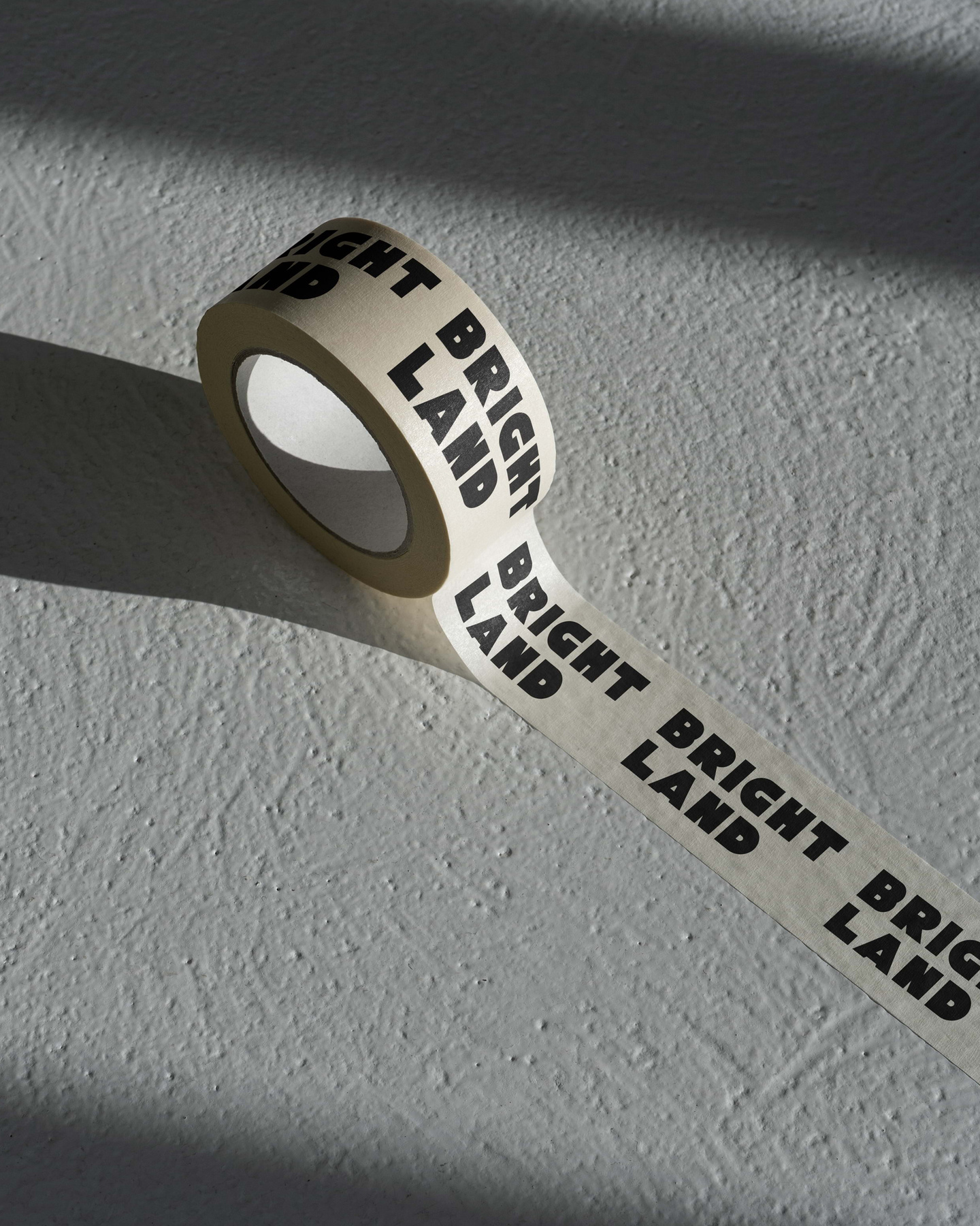 Roll of printed white paper packaging tape displaying the Brightland logo.
