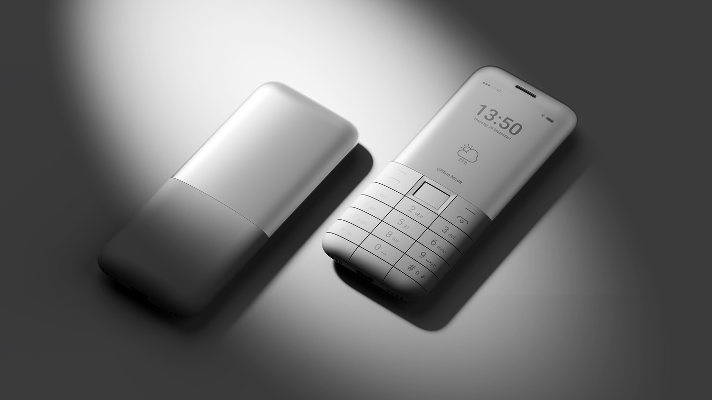 Pair of white keypad phones resting side-by-side illuminated by a spotlight.