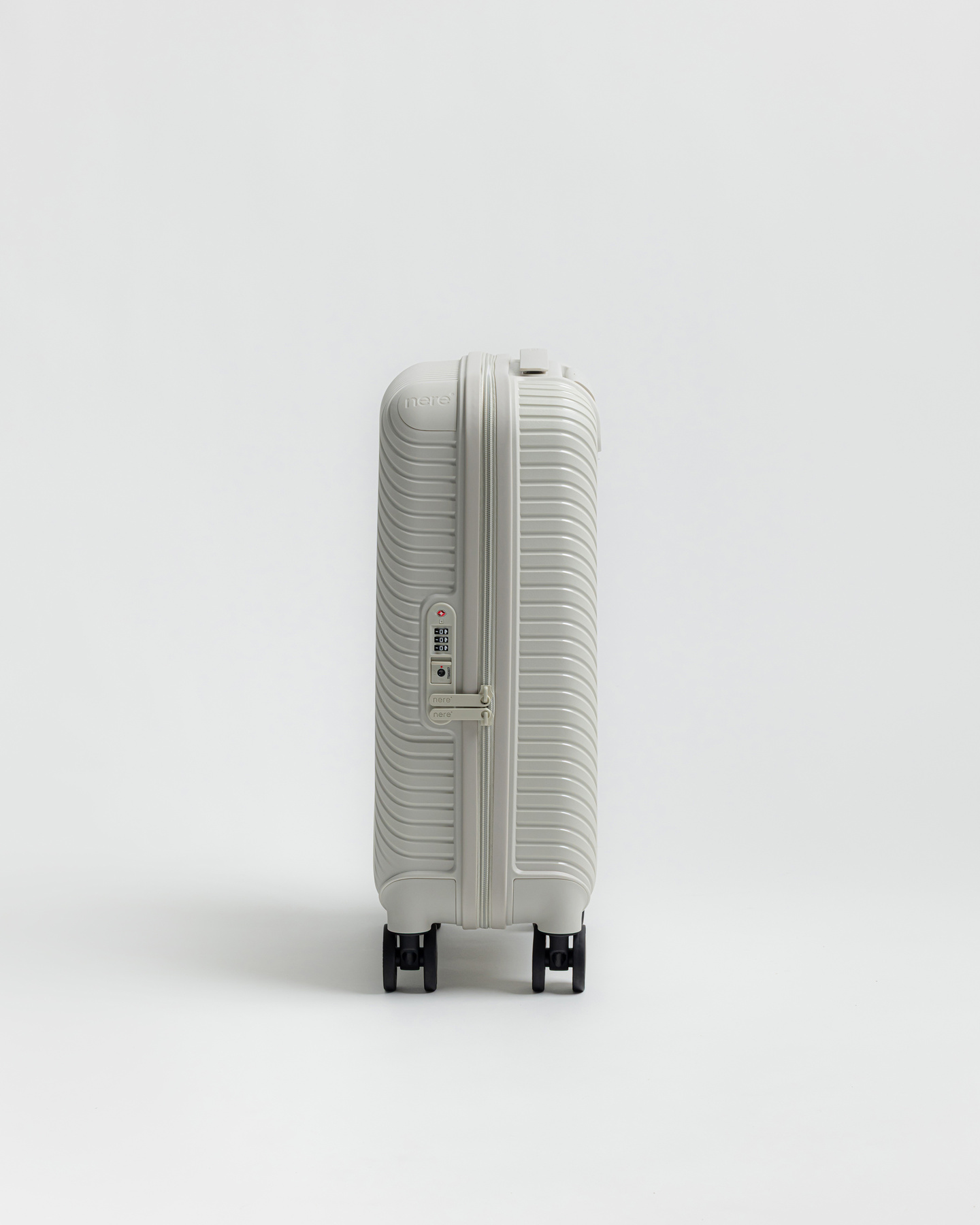 Distant view of a grey hardshell suitcase standing against a grey background