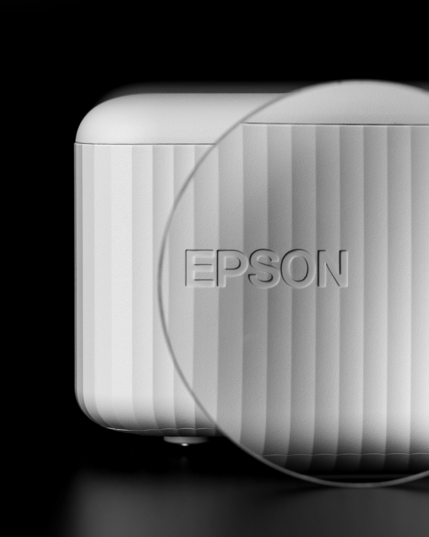 Front view of white projector with clear circular lens attachment