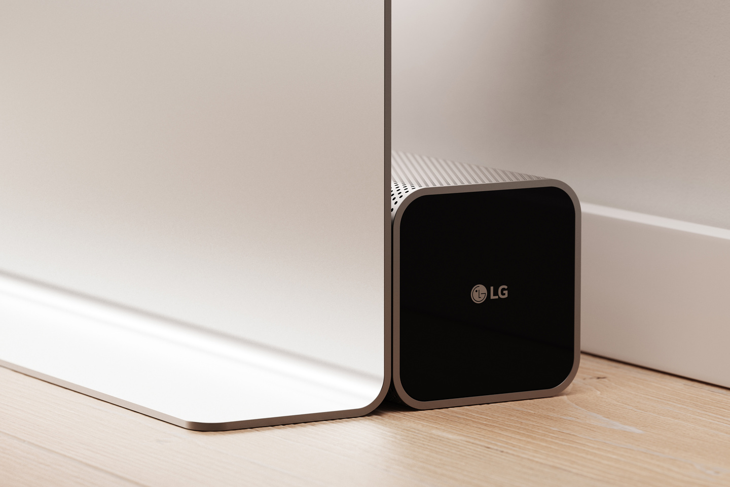 Black speaker connected to a wall module near floor level.