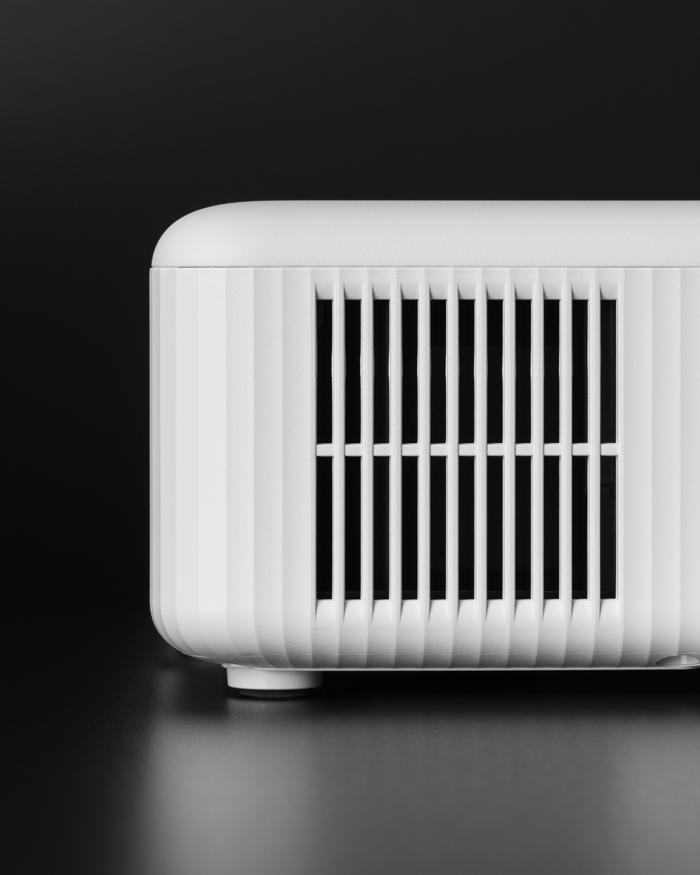 Close-up view of side ventilation grille on white projector body