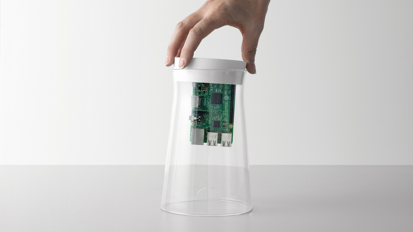 Hand lifting the top cap and internal circuit board from a glass cylinder unit.