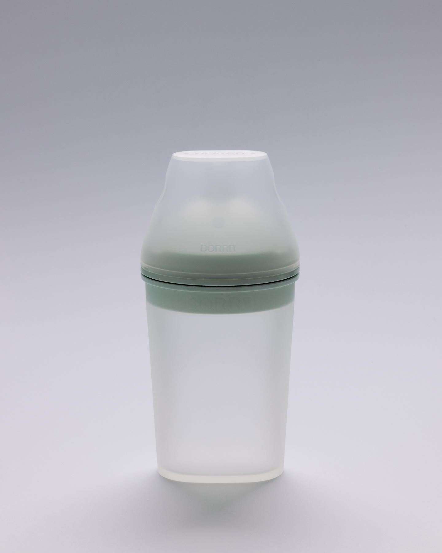 Tall white silicone baby feeding bottle with pale green collar standing upright.