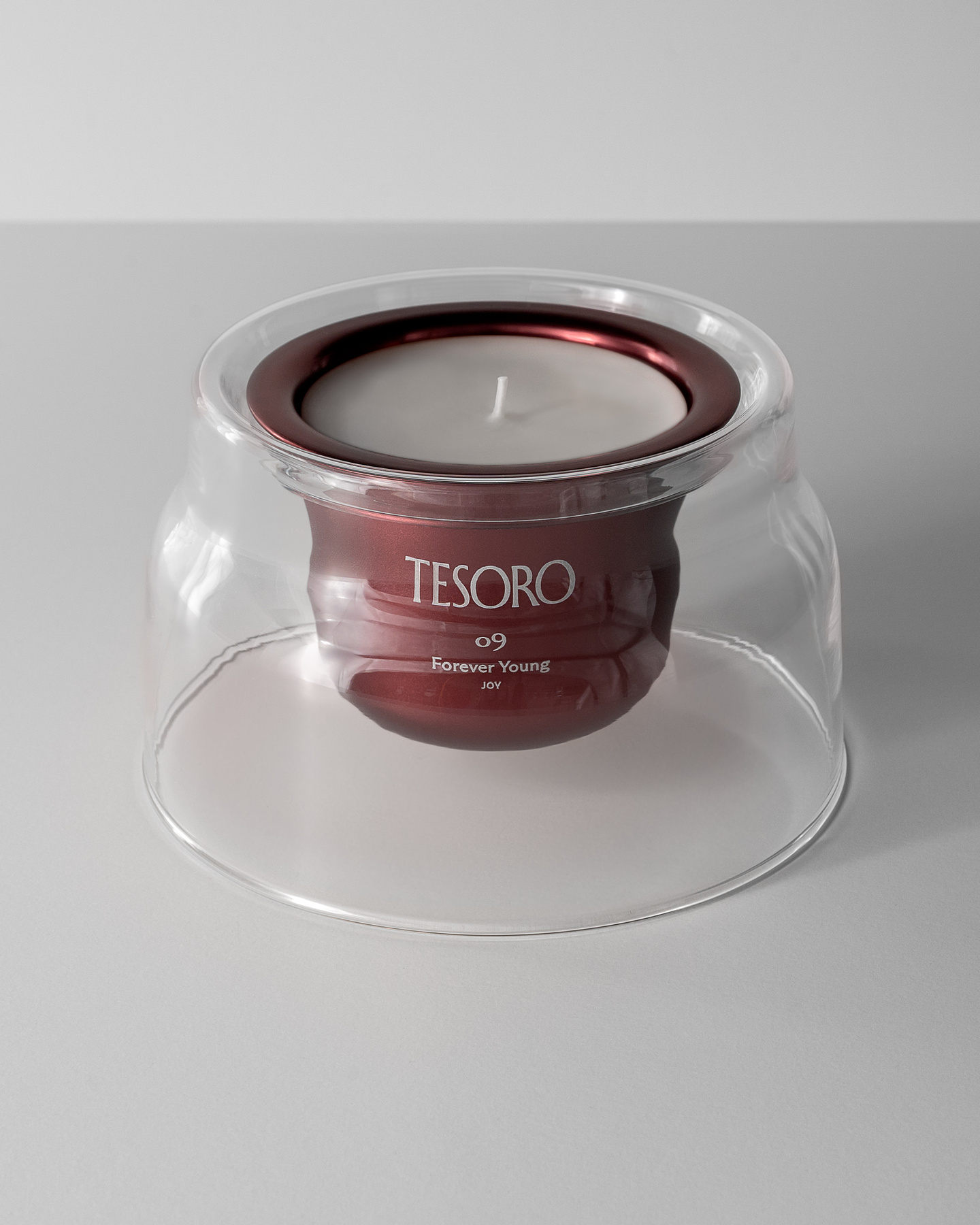 Dark metallic candle refill insert seated inside a clear glass vessel