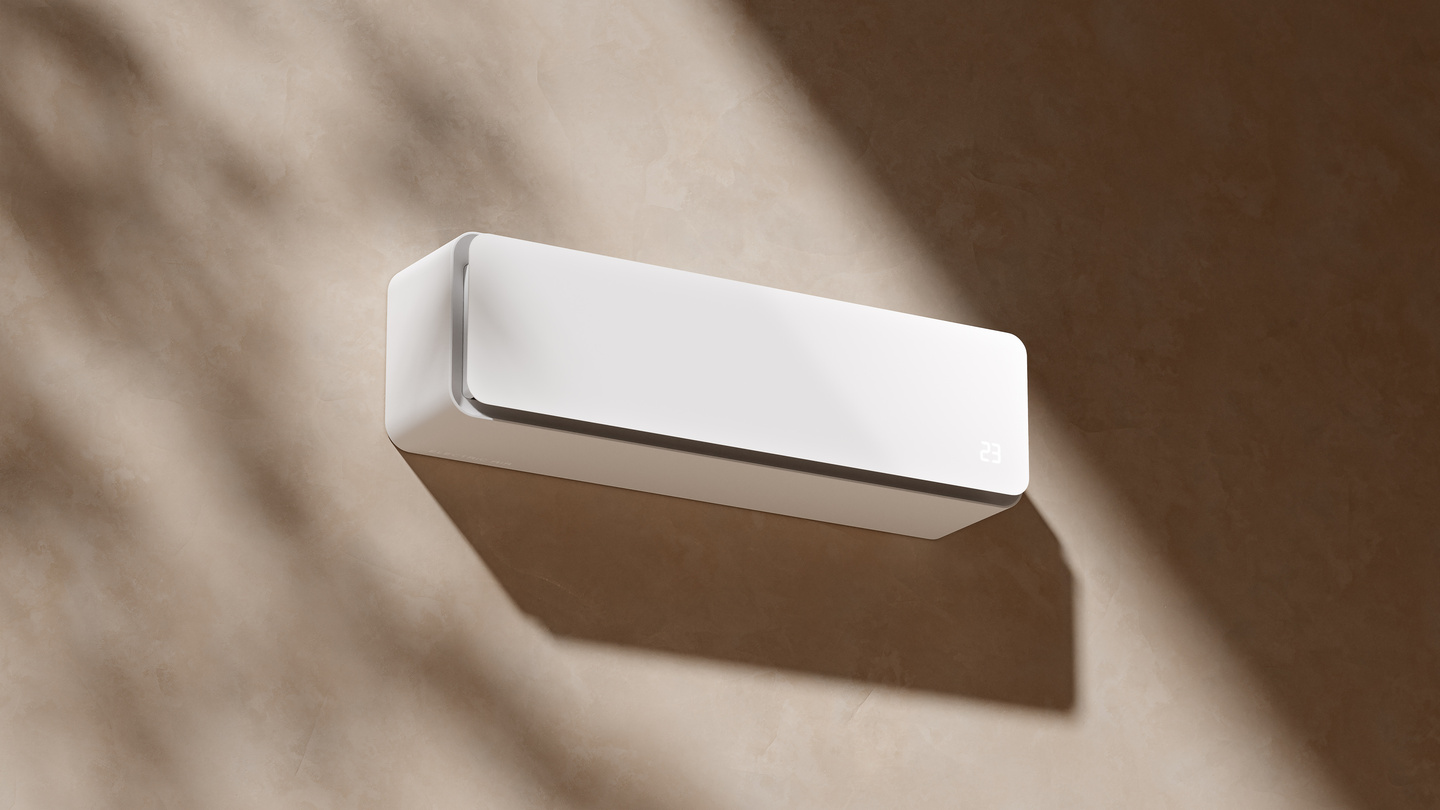 White wall-mounted HVAC unit mounted on a light wall with natural light shadows