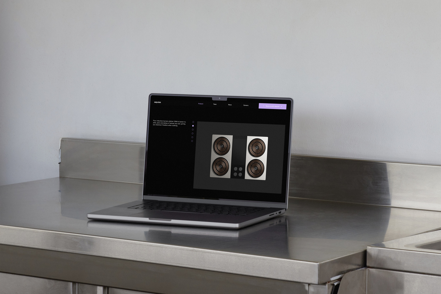 Laptop resting on a stainless steel counter showing website layout