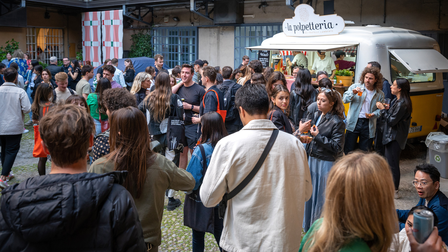 Large crowd of people gathered outside the venue during an exhibition opening event.