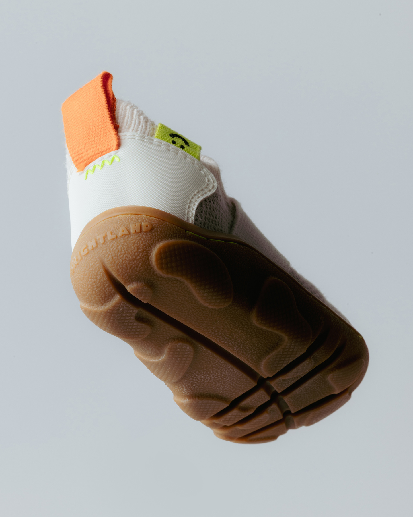 Studio shot showing the textured brown sole of a children's shoe.