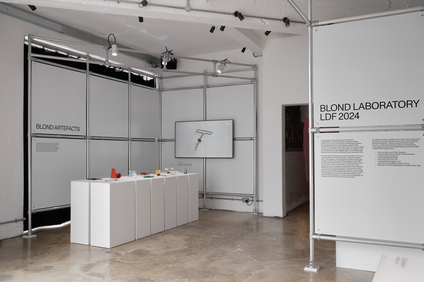 View of gallery with display pedestals and scaffolding with white panels