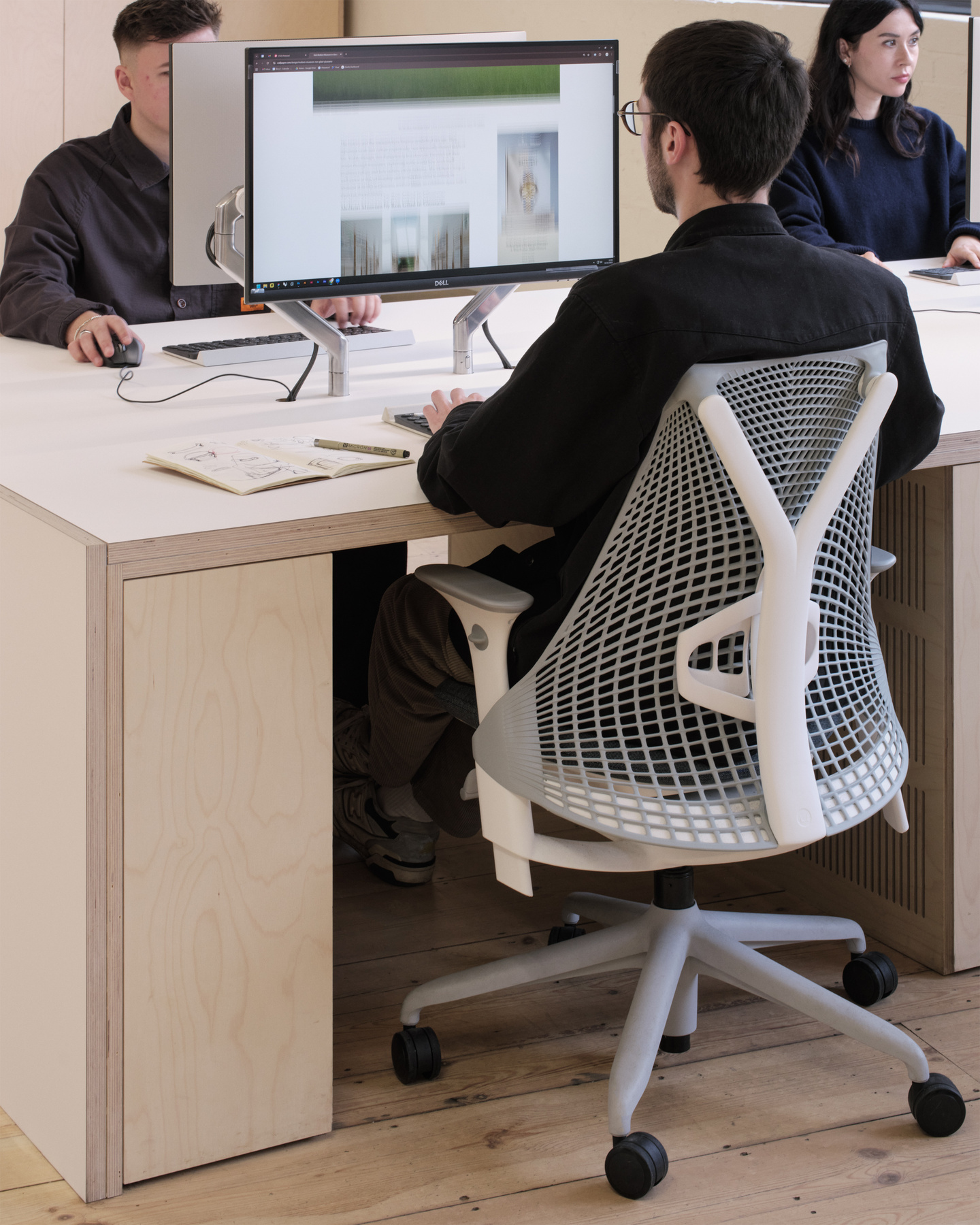 A photogaph of a designer in the workspace working on his computer