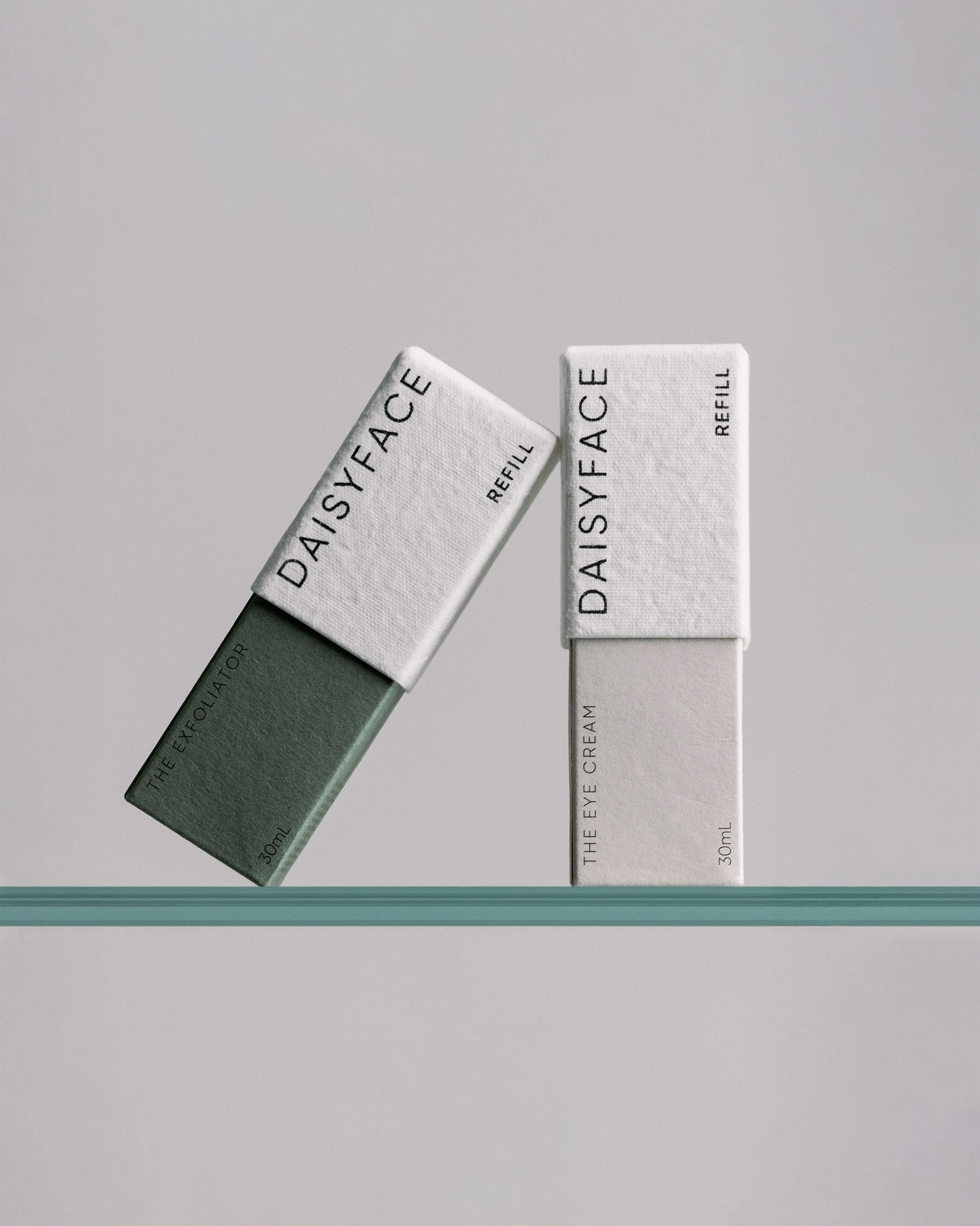 Grey and white refillable skincare packaging containers standing upright